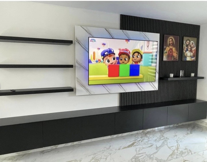 Wide view of charcoal acoustic media wall with three black floating shelves, marble TV back panel and long black matte cabinet