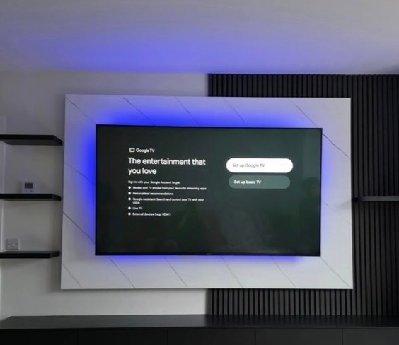 Close-up of recessed 75-inch TV on marble-effect back panel with colour-changing RGB LED backlight