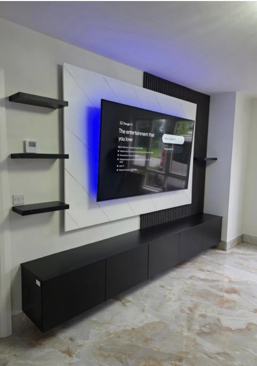 Wide view of media wall with marble TV back panel, acoustic charcoal panels, floating shelves and 300 cm black matte cabinet
