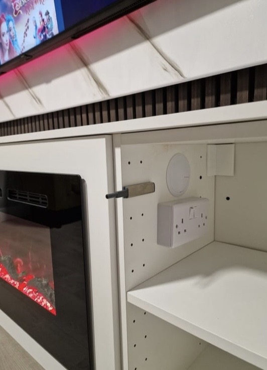 Inside cabinet detail showing double socket, fused switch for the electric fireplace and concealed HDMI cabling