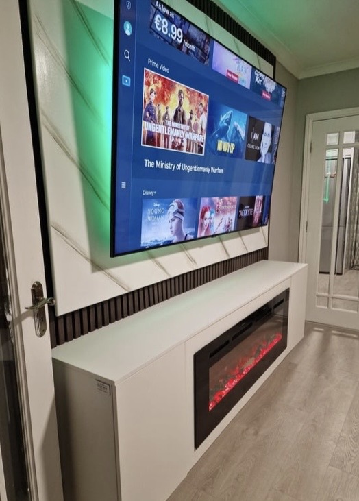 Close-up of 50-inch electric fireplace built into white floating unit beneath the 75-inch TV