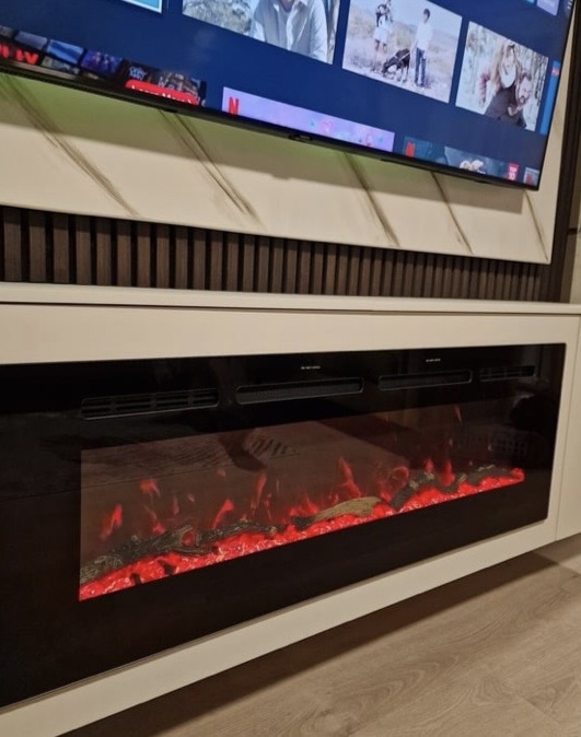 Angled view of marble-effect TV feature wall with Wenge acoustic panels and white floating cabinet with electric fireplace